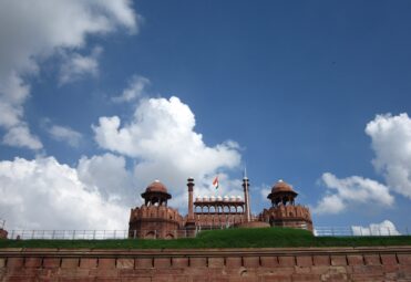 Indian national flag waving against a clear blue sky at Red Fort, Delhi